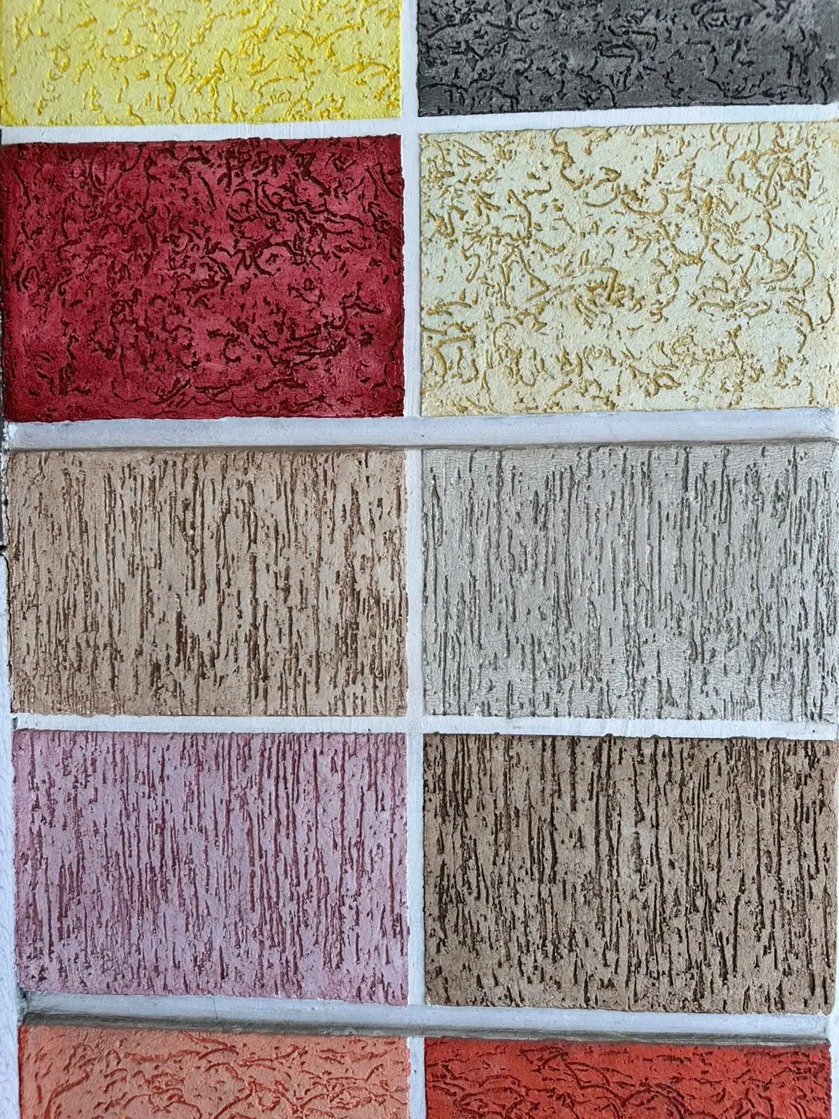 Cartela de amostras com gel envelhecedor sobre texturas de várias cores, com o tom escuro assentado dentro do relevo